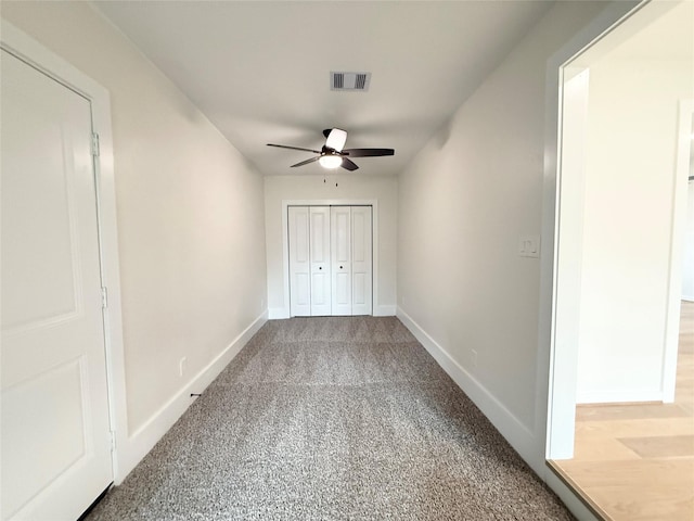 unfurnished room featuring carpet floors, a ceiling fan, visible vents, and baseboards