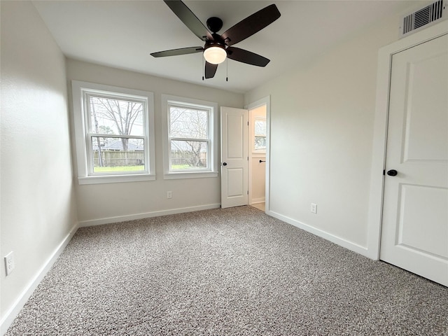 unfurnished bedroom featuring a ceiling fan, baseboards, visible vents, and carpet flooring