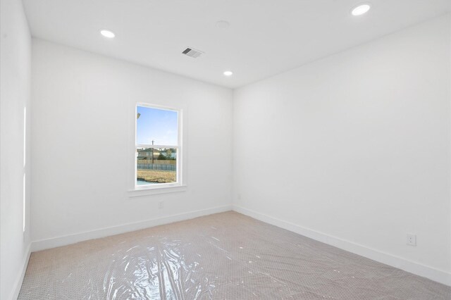 empty room featuring baseboards, visible vents, and recessed lighting