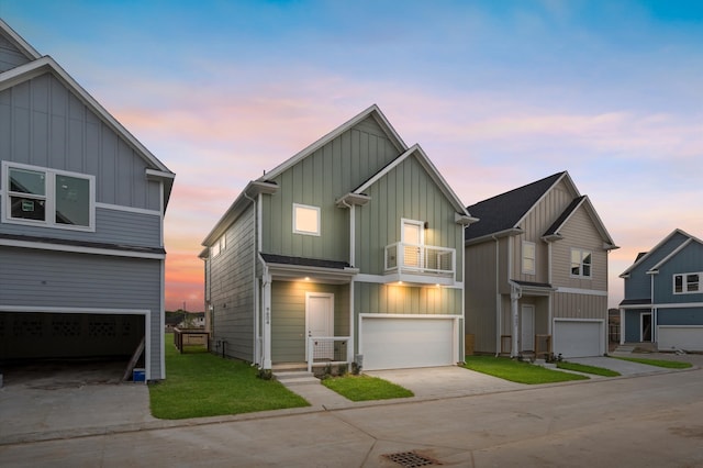 view of front of house with an attached garage, a balcony, concrete driveway, a yard, and board and batten siding