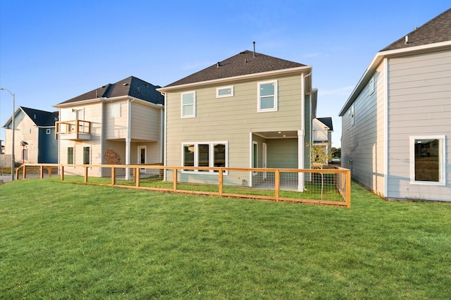 back of house featuring fence private yard and a yard