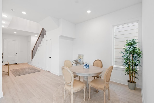 dining area featuring light wood-style floors, baseboards, stairway, and recessed lighting