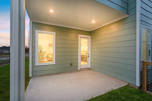 exterior entry at dusk featuring a patio area