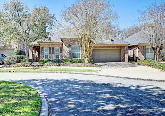 view of front of home featuring an attached garage, concrete driveway, and brick siding