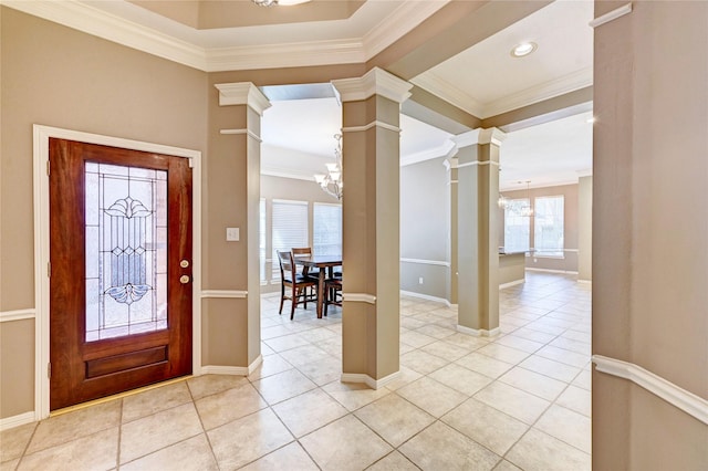 entryway featuring crown molding, a notable chandelier, decorative columns, and light tile patterned floors