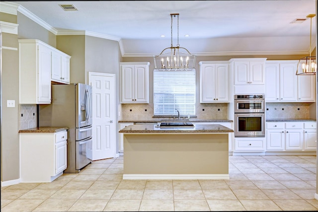 kitchen featuring appliances with stainless steel finishes, dark stone countertops, visible vents, and white cabinets