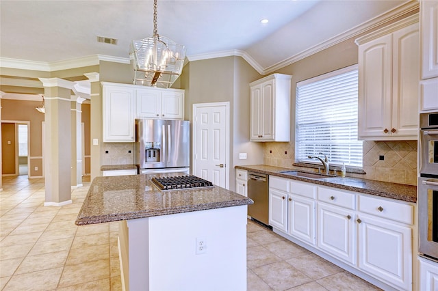 kitchen featuring decorative columns, visible vents, appliances with stainless steel finishes, a sink, and dark stone counters