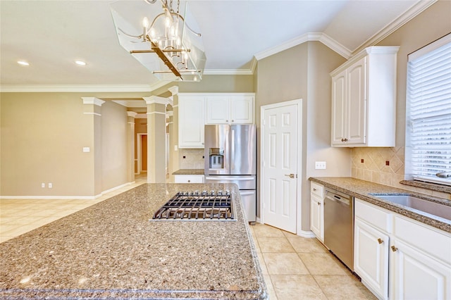 kitchen featuring light tile patterned floors, stainless steel appliances, a sink, white cabinetry, and ornamental molding