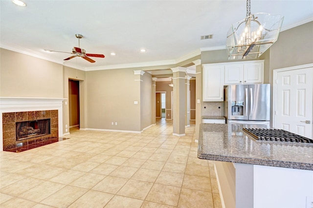 kitchen with white cabinets, a ceiling fan, appliances with stainless steel finishes, dark stone countertops, and backsplash