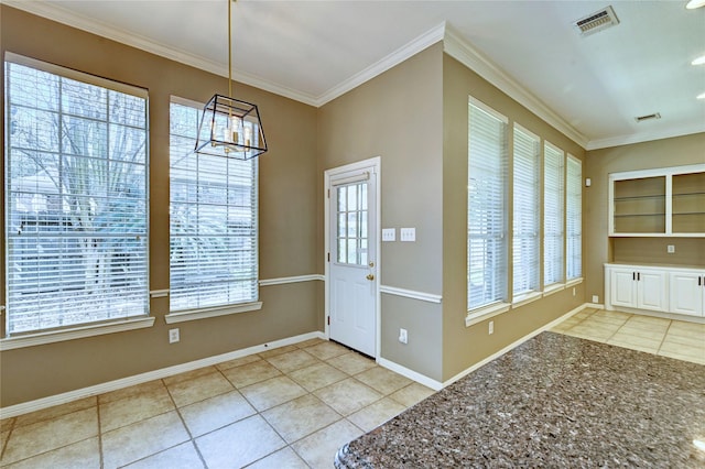 foyer with light tile patterned floors, visible vents, and crown molding