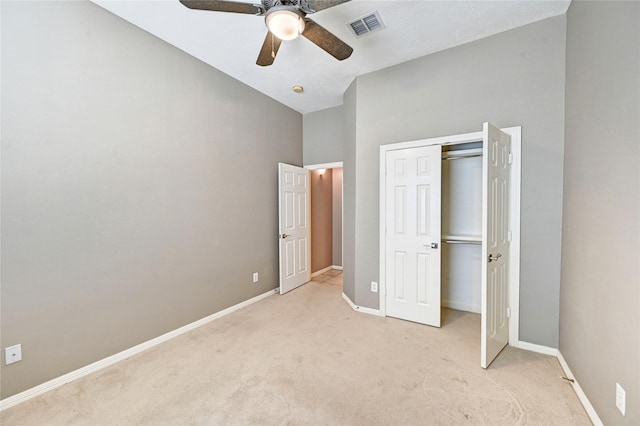 unfurnished bedroom featuring a closet, visible vents, light carpet, ceiling fan, and baseboards