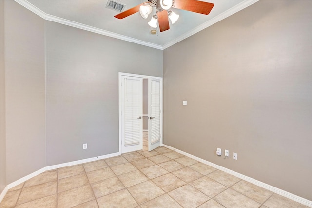 spare room with light tile patterned floors, baseboards, visible vents, and ornamental molding