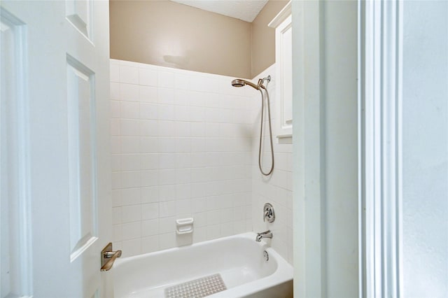 bathroom featuring bathtub / shower combination and a textured ceiling