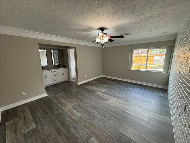 unfurnished bedroom featuring dark wood-style floors, crown molding, a textured ceiling, and baseboards