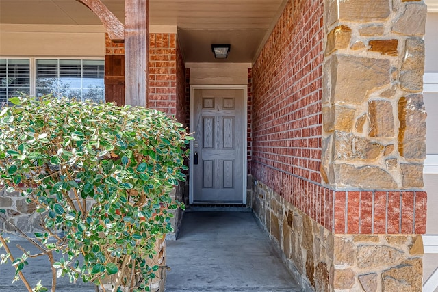 doorway to property featuring brick siding