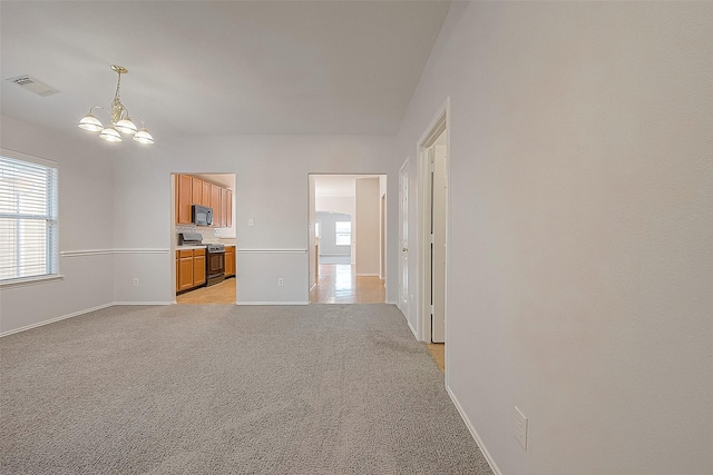 unfurnished living room featuring light carpet, a chandelier, visible vents, and baseboards