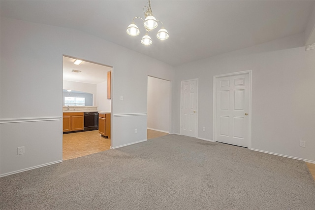 interior space with ensuite bathroom, a notable chandelier, light carpet, a sink, and visible vents