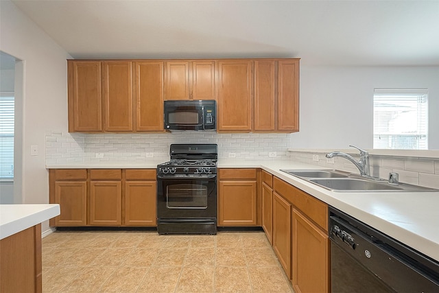 kitchen with light countertops, a sink, backsplash, and black appliances