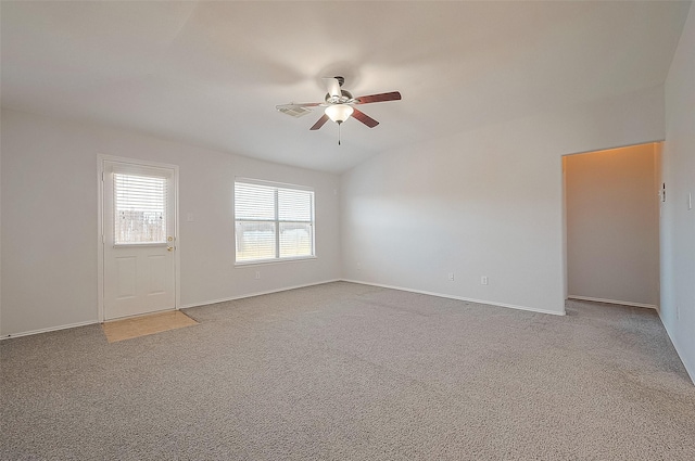 carpeted spare room featuring ceiling fan, lofted ceiling, and baseboards