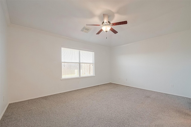 spare room featuring carpet floors, visible vents, ornamental molding, ceiling fan, and baseboards