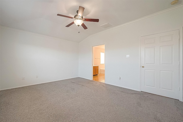 unfurnished bedroom with ornamental molding, light colored carpet, vaulted ceiling, and ensuite bath