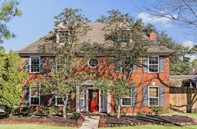 view of front of property with a chimney and fence