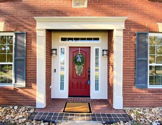 doorway to property featuring brick siding