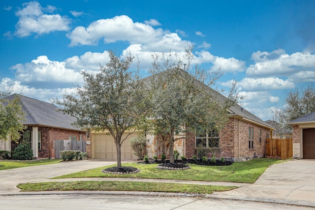 view of property hidden behind natural elements featuring brick siding, driveway, an attached garage, and fence