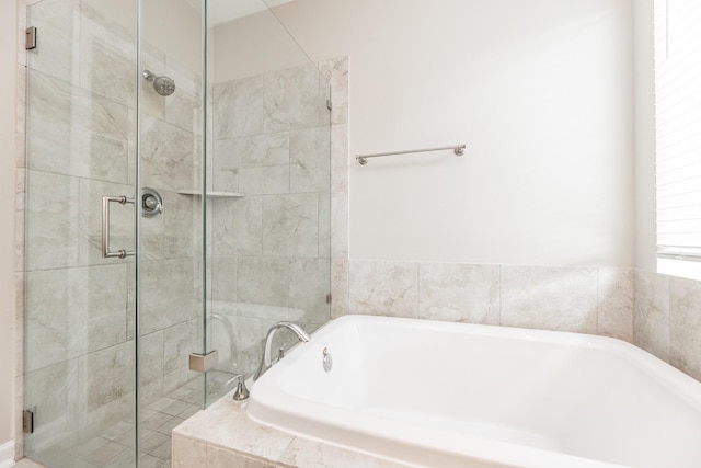 bathroom featuring a shower stall and a garden tub