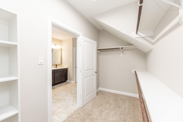 walk in closet featuring light carpet and a sink