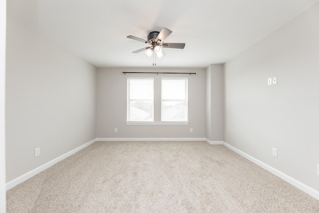 empty room with baseboards, light carpet, and a ceiling fan