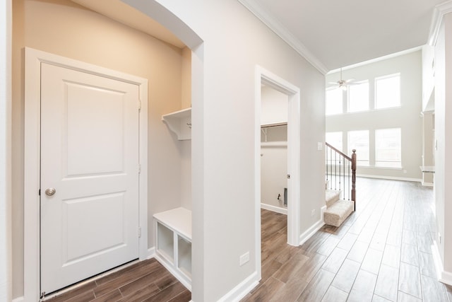 mudroom with crown molding, ceiling fan, baseboards, wood finish floors, and arched walkways