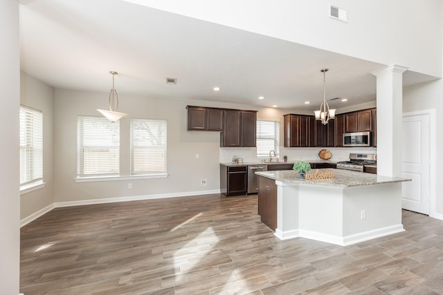 kitchen featuring stainless steel appliances, plenty of natural light, light wood-style floors, and dark brown cabinets