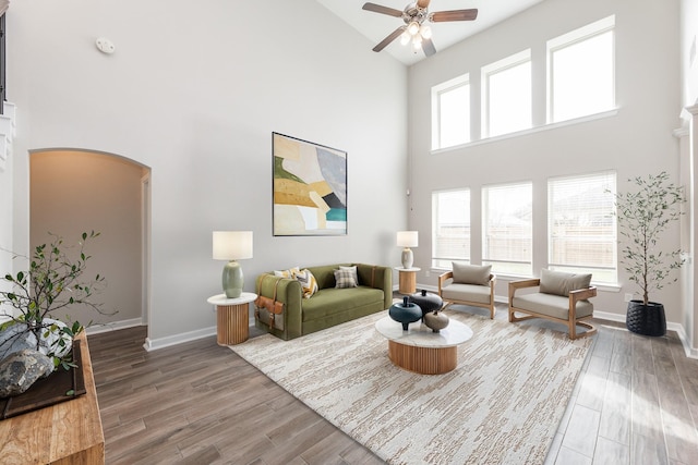 living room featuring wood finished floors, arched walkways, and a wealth of natural light