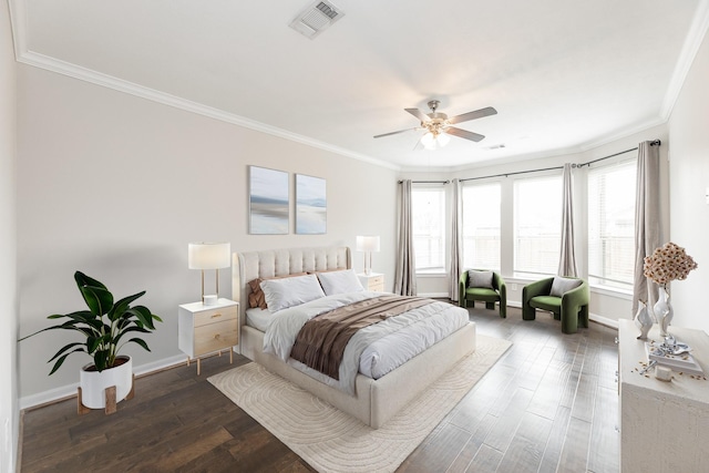 bedroom with visible vents, baseboards, wood finished floors, and ornamental molding