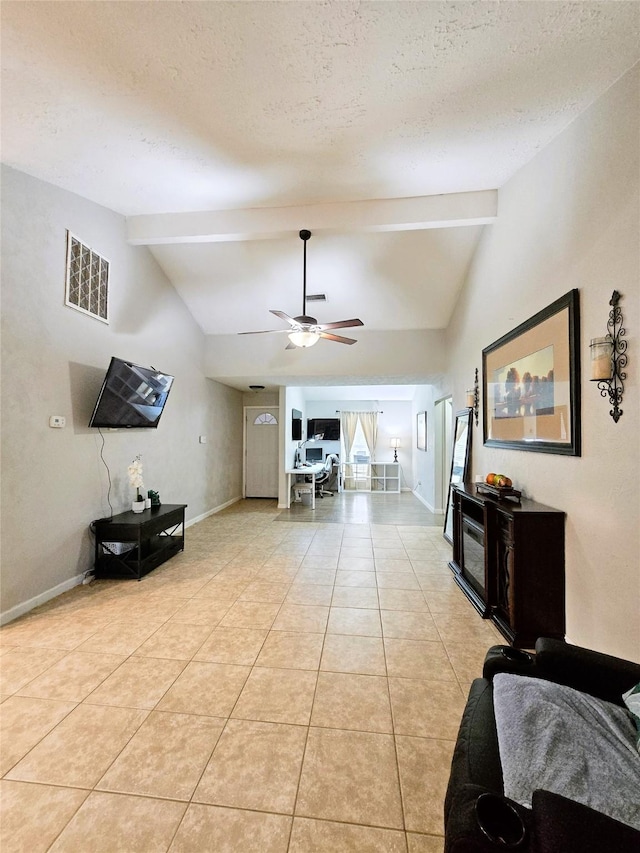 living area featuring vaulted ceiling with beams, light tile patterned floors, visible vents, and baseboards