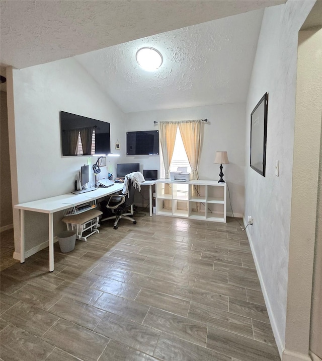 office with wood tiled floor, baseboards, vaulted ceiling, and a textured ceiling