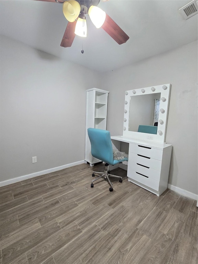 office space featuring baseboards, visible vents, ceiling fan, and wood finished floors