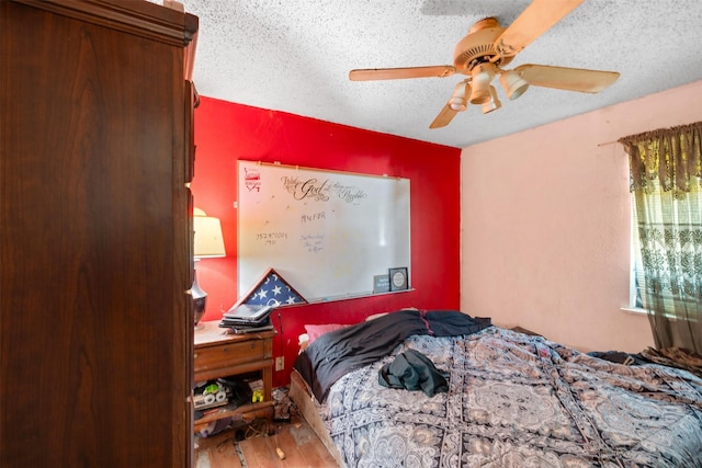 bedroom with ceiling fan, a textured ceiling, and wood finished floors