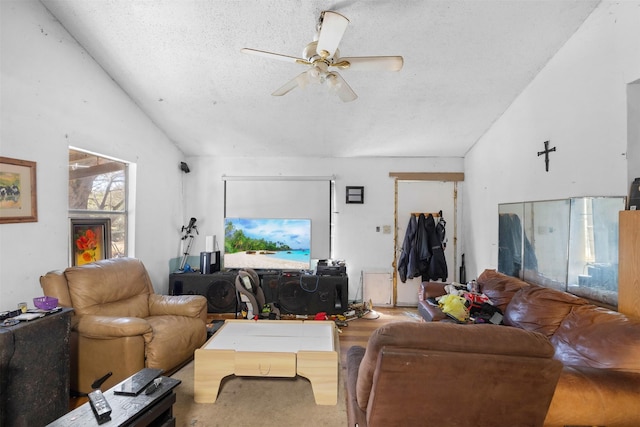 living area with vaulted ceiling, ceiling fan, and a textured ceiling