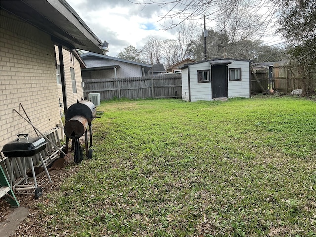 view of yard with a storage unit, an outdoor structure, a fenced backyard, and central air condition unit