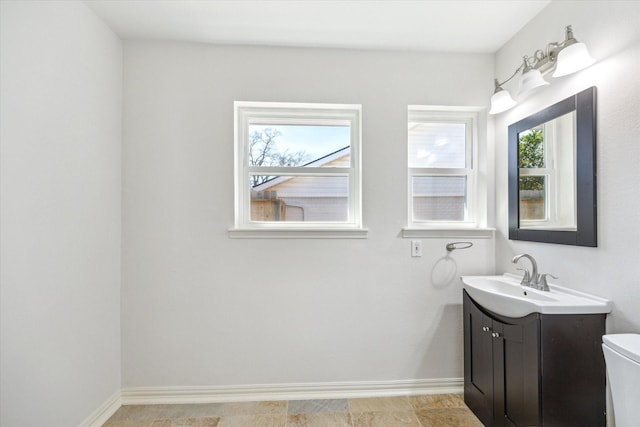 bathroom featuring baseboards, vanity, and toilet