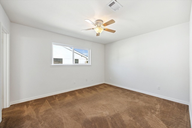 carpeted spare room featuring visible vents, ceiling fan, and baseboards