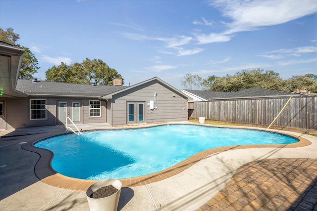 view of swimming pool with a fenced in pool, french doors, fence, and a patio