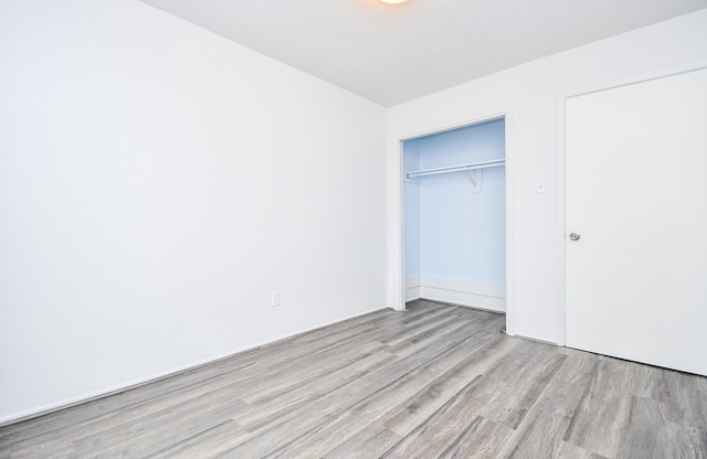 unfurnished bedroom with a closet and wood finished floors