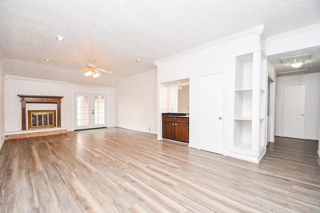 unfurnished living room with french doors, crown molding, light wood finished floors, a ceiling fan, and a textured ceiling