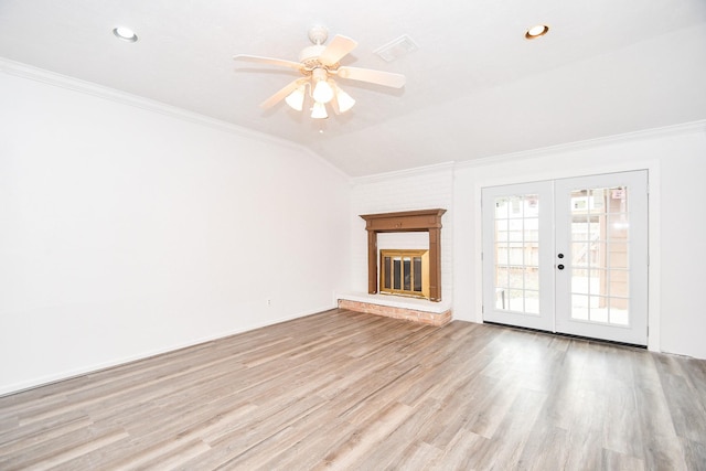 unfurnished living room featuring vaulted ceiling, french doors, light wood-style flooring, and crown molding