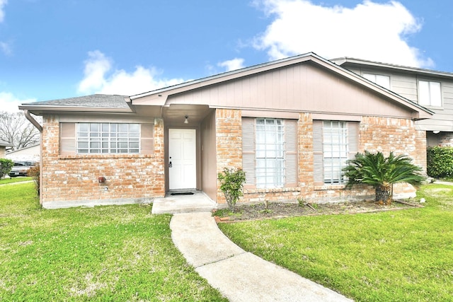 view of front facade with a front yard and brick siding