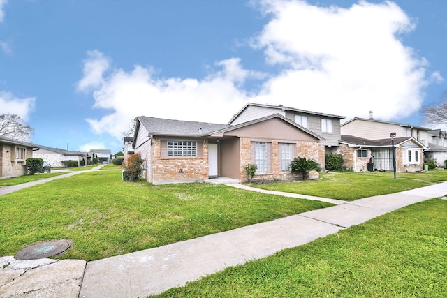 view of front facade featuring a front yard and brick siding