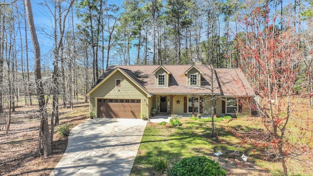 cape cod-style house featuring a front yard, covered porch, driveway, and an attached garage